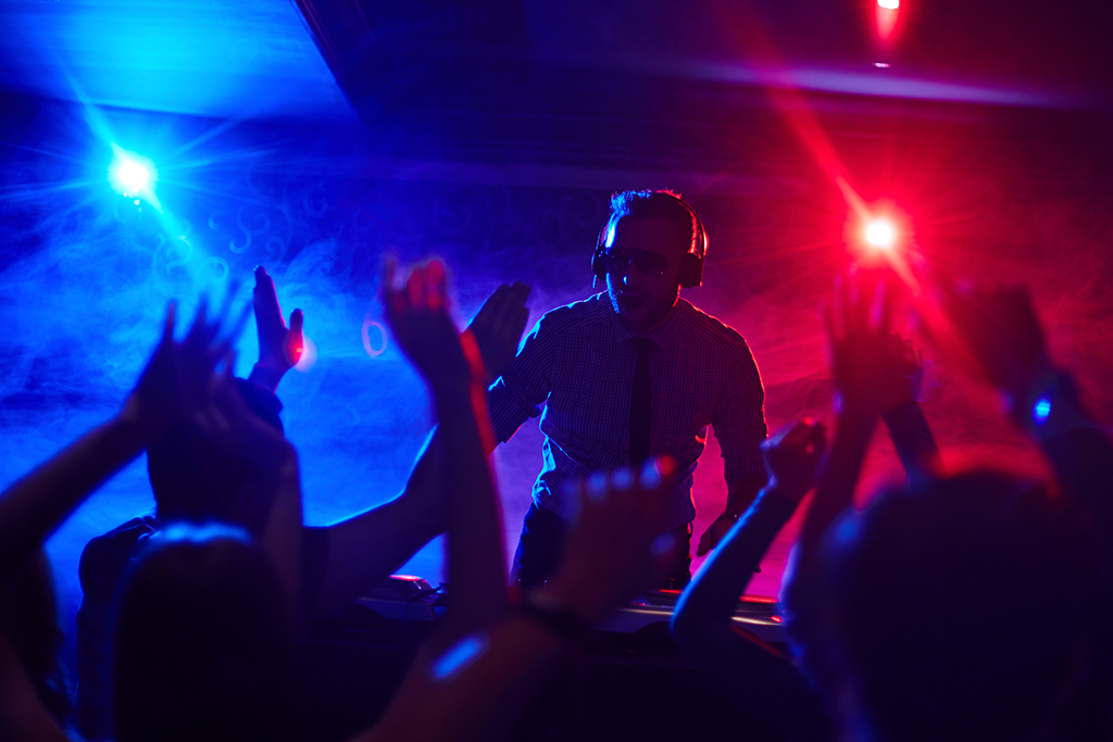DJ soittaa musiikkia klubilla ja ihmiset tanssivat