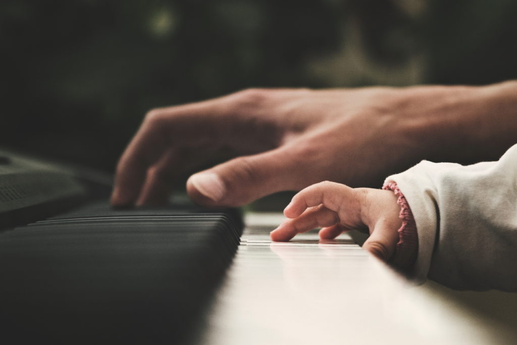 aikuinen ja pieni lapsi soittavat pianoa