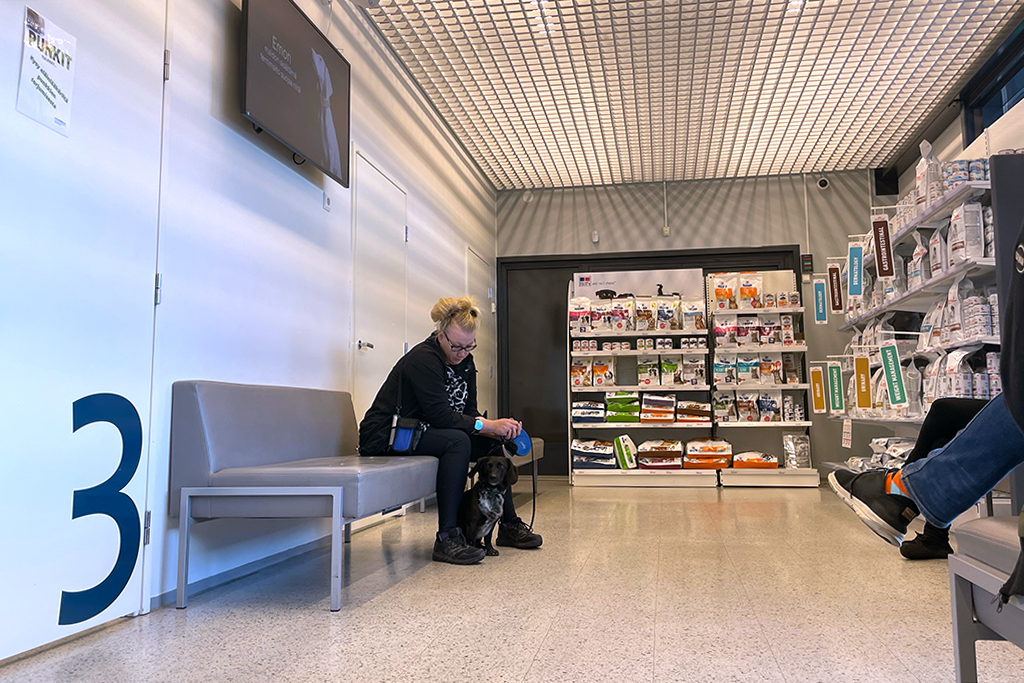 Nainen odottaa koiransa kanssa eläinlääkärissä